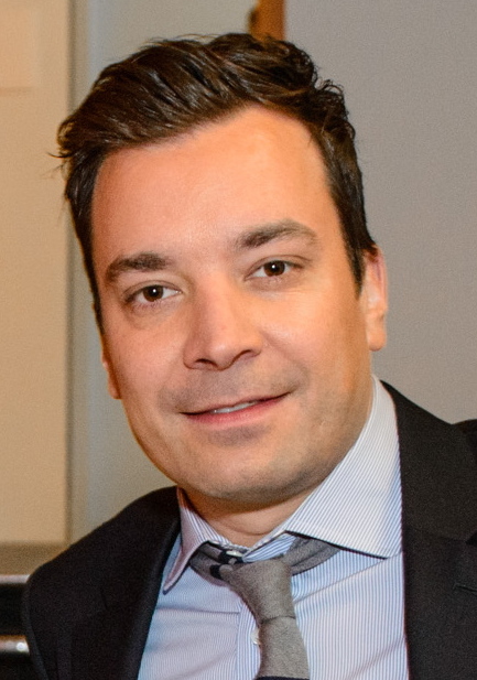 Man with neatly styled dark hair wearing formal attire, posing at an indoor event