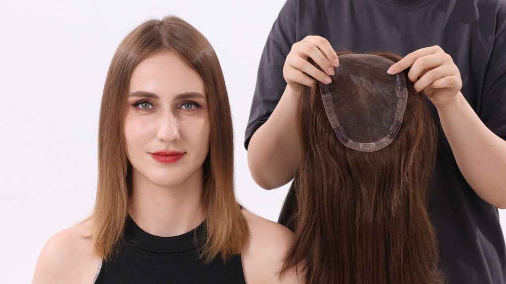 A stylist is demonstrating how to put on a hair topper on a female client's head