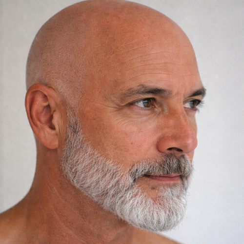 man with a clean shaved head and a silver beard