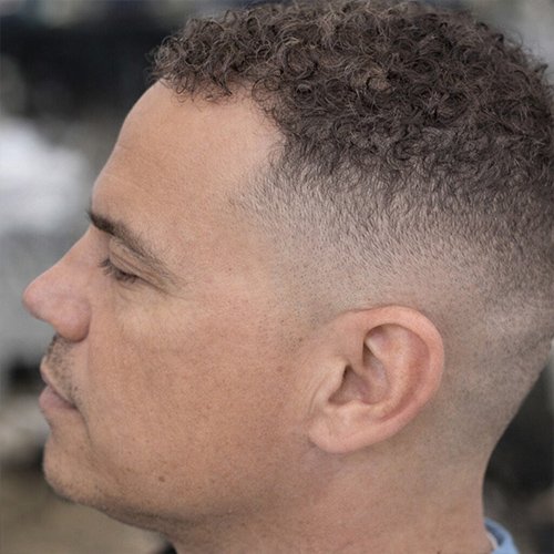 a guy with a short curly crop