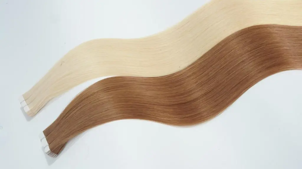 Blonde and warm brown Tape-In hair extensions with flat adhesive tabs, shown as a stage 1 entry-level salon extension option for fast installation and flexible inventory.