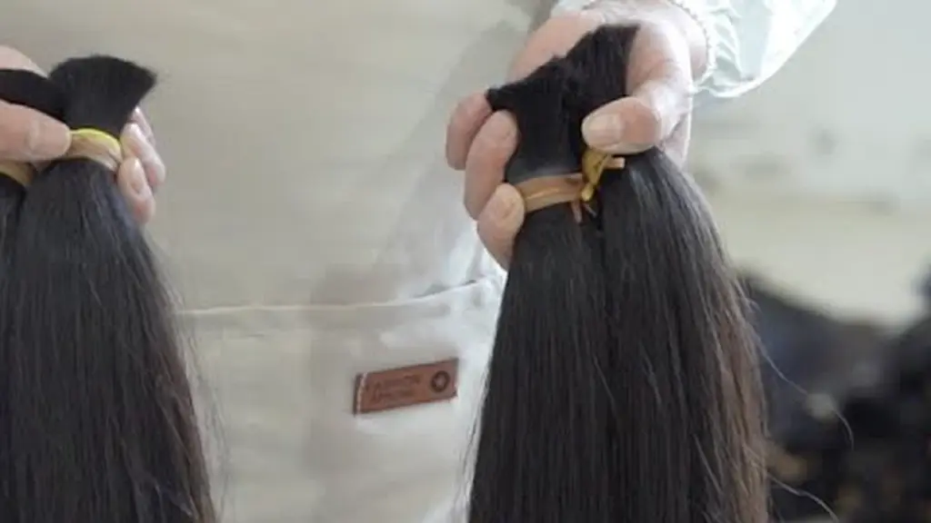 Bundles of raw human hair being compared during sorting.