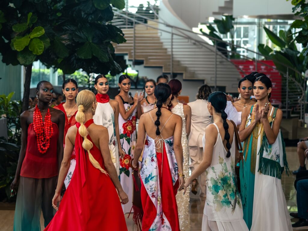 Runway models wearing colorful designer dresses and ponytail hairstyles at the L’Espace Puerto Rico 2026 fashion show.